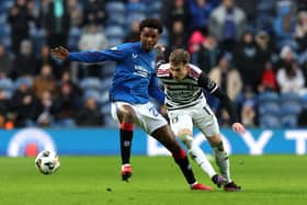 Rafael Fernandes of Rangers FC runs for the ball under pressure from Kyle Hurst of Queens Park