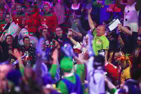 A fan dressed up as Michael van Gerwen stands up to acknowledge the crowd 