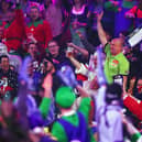 A fan dressed up as Michael van Gerwen stands up to acknowledge the crowd 