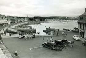 Millport Harbour in the 1950s with taxis and horse carriage ready to take visitors round the island.