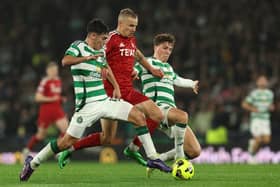 Topi Keskinen of Aberdeen is challenged by Alex Valle and Arne Engels of Celtic 