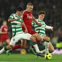 Topi Keskinen of Aberdeen is challenged by Alex Valle and Arne Engels of Celtic 