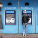 A man uses a cashpoint machine at a Barclays Bank 