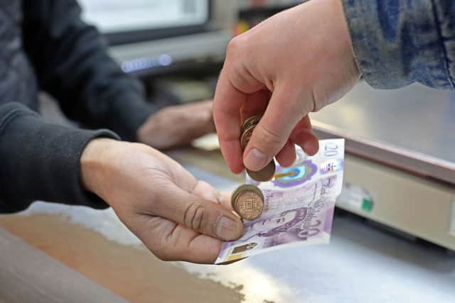 A customer pays for goods inside a shop. Christmas and New Year bank holidays can change when benefit payments are made in Scotland (Photo: SUSANNAH IRELAND/AFP via Getty Images)