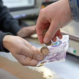 A customer pays for goods inside a shop. Christmas and New Year bank holidays can change when benefit payments are made in Scotland (Photo: SUSANNAH IRELAND/AFP via Getty Images)