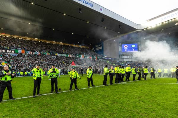 Police form a barricade to stop and block fans getting onto the pitch after the Scottish Cup quarter-final between Rangers and Celtic at Ibrox Stadium. (Photo by Craig Williamson / SNS Group)