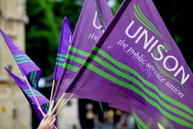 Purple and green Unison flags being waved