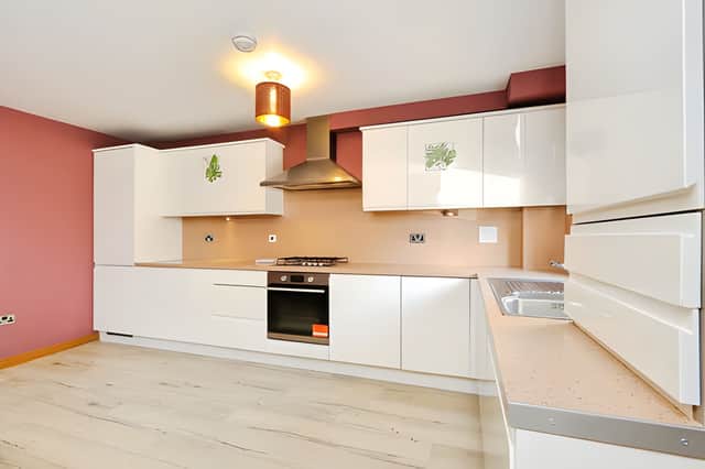 White wall and floor units give the fitted kitchen a contemporary feel, while space for dining helps make the open-plan layout practical for everyday life
