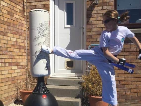 Emma Swan shows off her taekwon-do kicking skills at home.