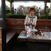 First Minister Nicola Sturgeon sits by a fire pit table during a visit to Cold Town House in Edinburgh's Grassmarket, where she saw the changes in place to keep staff and customers safe in the outdoor hospitality industry. Photo by Andrew Milligan - Pool/Getty Images