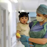 Nurse Lindsay Macdonald reassures little Hannah on the way to the operating theatre.