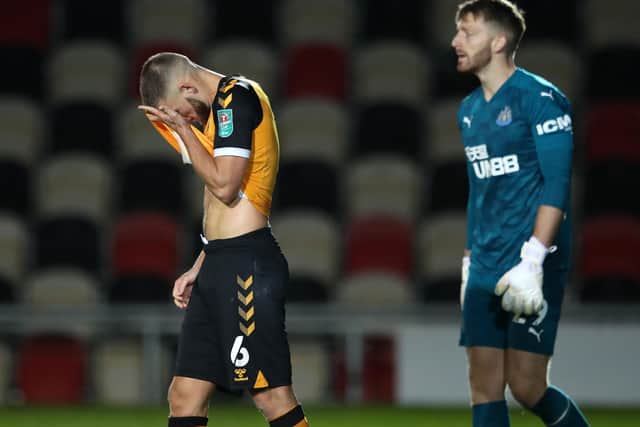 Newport County's Welsh defender Brandon Cooper reacts after missing during a penalty shootout as Newcastle United goalkeeper Mark Gillespie walks off the pitch after his side won the game 5-4 on penalties. (Photo by Alex Pantling/pool/AFP via Getty Images)