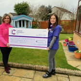 Gill is pictured handing over a cheque for £10,600 to Amanda Harris, from Cancer Research UK.