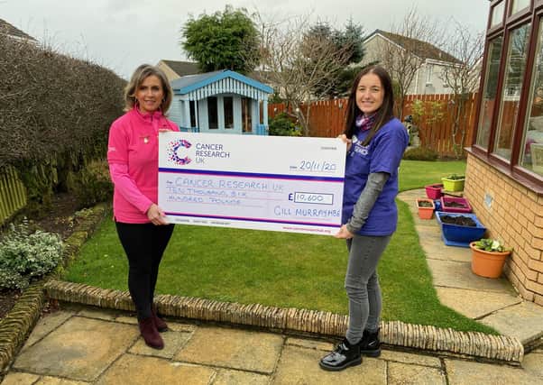 Gill is pictured handing over a cheque for £10,600 to Amanda Harris, from Cancer Research UK.