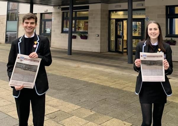 Head boy Jude Sonvico and head girl Maria Docherty with a copy of last week’s Herald, with the full-page advert