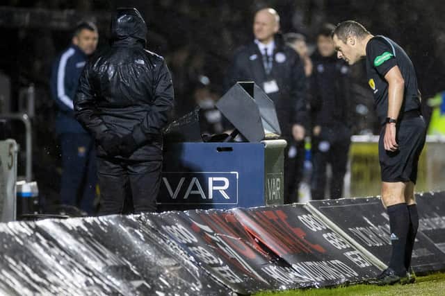 Referee Euan Anderson consults the VAR monitor for on on-field review. (Photo by Roddy Scott / SNS Group)