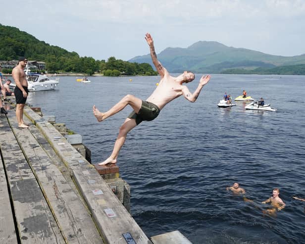Swimmers jumping into Loch Lomond from a pier at Luss Picture: Andrew Milligan/PA Wire