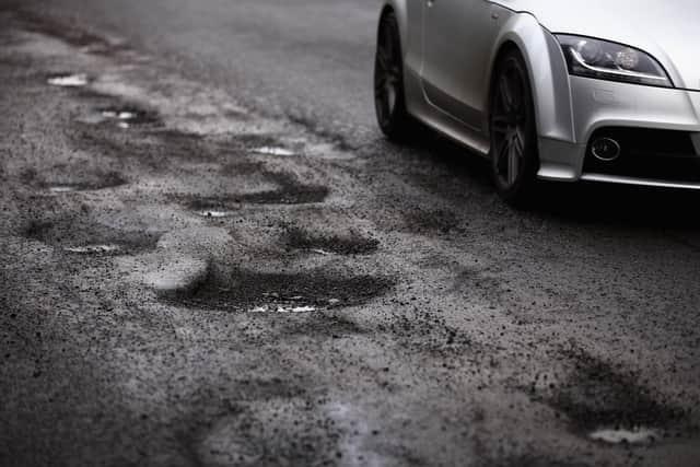 A road user tries to avoid potholes in Glasgow