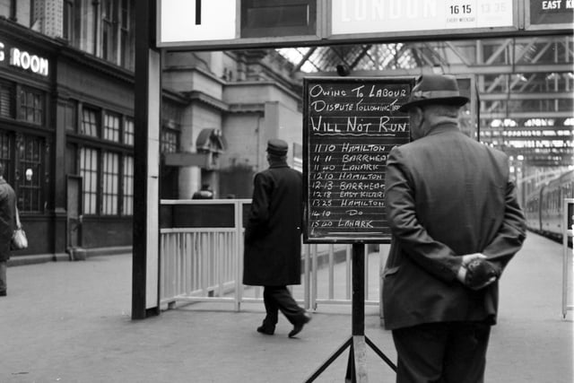 Passenger checks the non-availability of trains on the notice board at Glasgow Central during the strike of June 1967