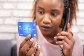 Woman With Credit Card Using Landline Phone