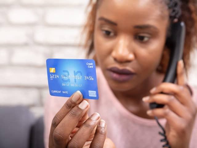 Woman With Credit Card Using Landline Phone