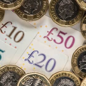 UK five pound, ten pound, twenty pound and fifty pound notes with one pound coins.