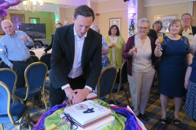 Gerry O'Hare cuts the anniversary cake