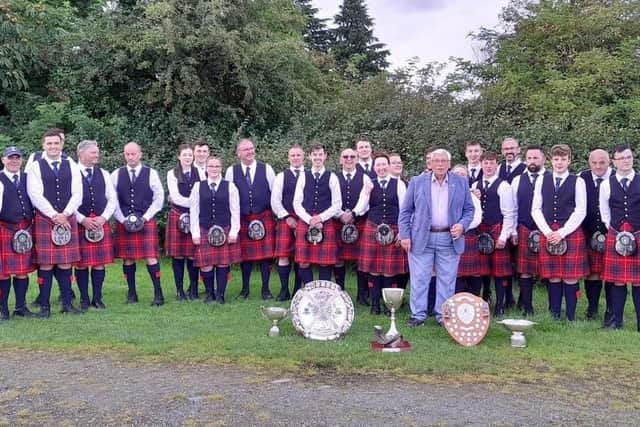 Band members celebrate following their success at Cowal Highland Games, where they secured three first place finishes as well as three first places for drumming.