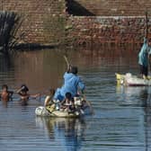 People use rafts to cross a flooded area after monsoon rains on the outskirts of Sukkur, Sindh province. 