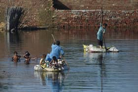 People use rafts to cross a flooded area after monsoon rains on the outskirts of Sukkur, Sindh province. 