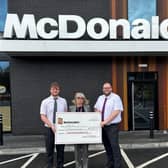 Franchisee team delivering cheque to charity.