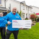 Paul Mcilvenny and Elise Kelly from Include Me 2 Club receives a donation of £1,000 from Taylor Wimpey’s local sales executive Lorraine Scouller at Duncarnock in Barrhead. Pic: Iain McLean