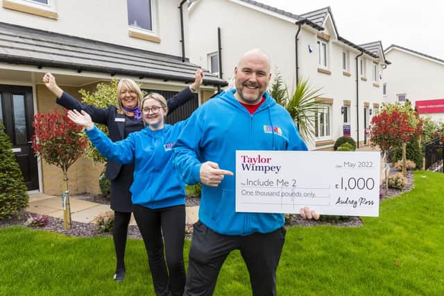 Paul Mcilvenny and Elise Kelly from Include Me 2 Club receives a donation of £1,000 from Taylor Wimpey’s local sales executive Lorraine Scouller at Duncarnock in Barrhead. Pic: Iain McLean