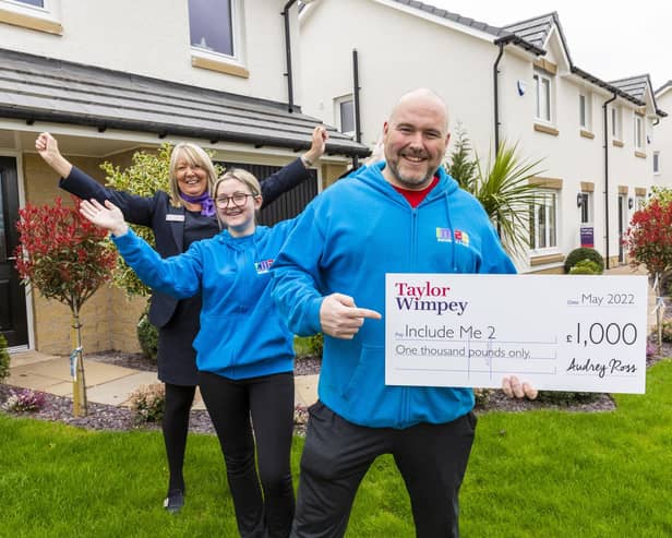 Paul Mcilvenny and Elise Kelly from Include Me 2 Club receives a donation of £1,000 from Taylor Wimpey’s local sales executive Lorraine Scouller at Duncarnock in Barrhead. Pic: Iain McLean