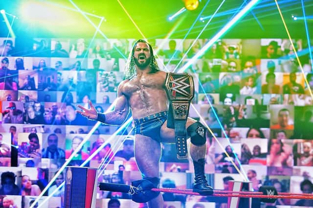 Drew McIntyre celebrates his second WWE championship win in front of the company's virtual fan wall utilised during the coronavirus pandemic.