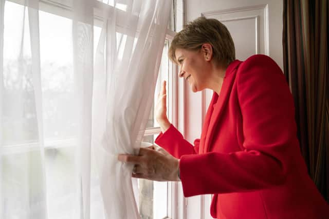 First Minister Nicola Sturgeon waves to people gathered outside Bute House in Edinburgh, after announcing that she will stand down as First Minister of Scotland. (Photo credit: Jane Barlow/PA)