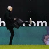 Jim Goodwin climbs over the Easter Road advertising hoardings after being dismissed as manager of Aberdeen following a 6-0 loss earlier this year. Picture: SNS