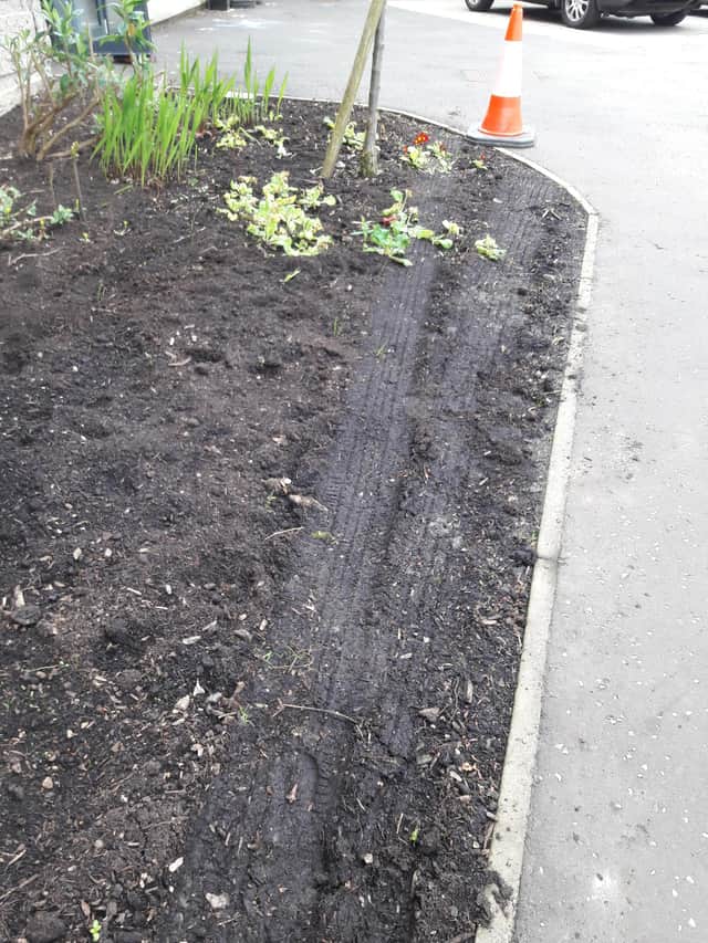 Sets of tyre tracks can be seen going over the flower bed