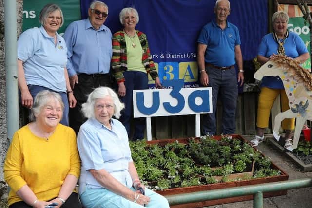 An afternoon tea had been planned for the U3A's 10th anniversary but the pandemic put paid to that. Instead, members unveiled a planter outside Morrisons. Inset: Margaret Dunlop presents a gift to Gavin Paton.