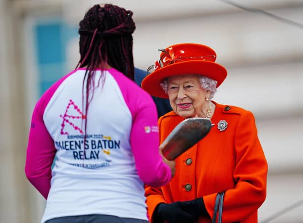 <p>Queen Elizabeth II passes her baton to the baton bearer, British parasport athlete Kadeena Cox. (Photo by Victoria Jones - WPA Pool/Getty Images)</p>