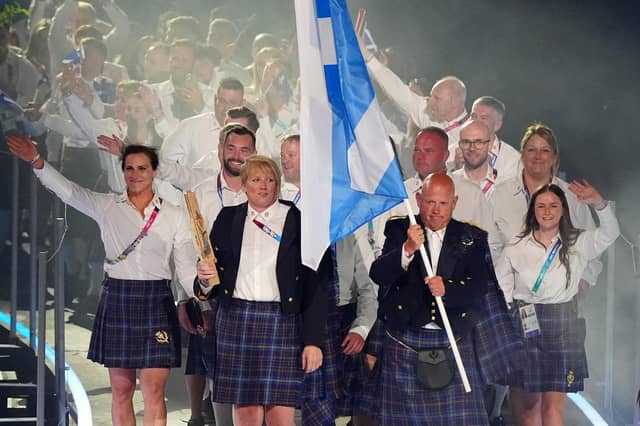 Alex Marshall, flag bearer of Scotland alongside Sarah Adlington, baton bearer leads their delegation during the opening ceremony