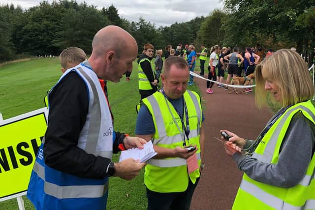 Volunteers help keep track of runners times and positions.