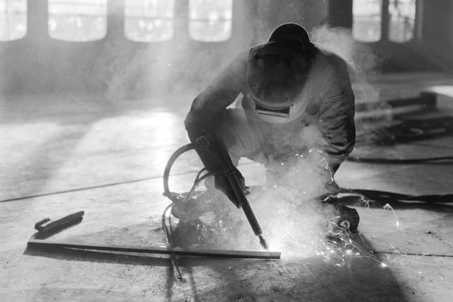 The Queen Elizabeth II liner being fitted out at John Browns shipyard in Clydebank in December 1967 - here a welder works on the floor of the ship.