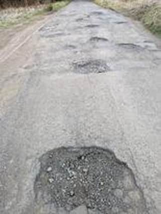 Moon-like surface on pothole-laden road at Lennoxtown