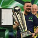 Luke Littler poses with the Sid Waddell Trophy after victory over Michael van Gerwen in the PDC World Darts Championship final at Alexandra Palace in London on Friday