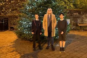 Amy Ted and Alexander pictured in front of the community tree.