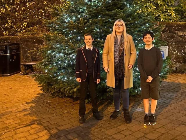 Amy Ted and Alexander pictured in front of the community tree.