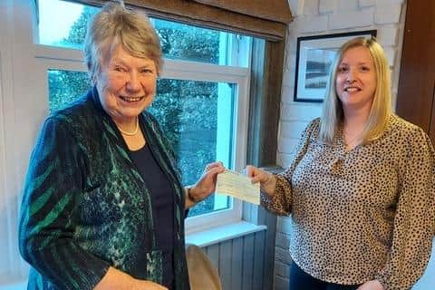 Joan MacMillan presents a cheque for £13,521 to Sylvia Russell.