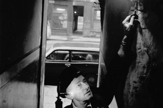 James McKay lighting a gas lamp in a tenement stair in Glasgow during the power cuts of December 1970.