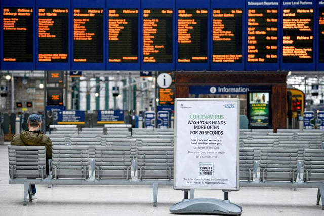 A sign telling people to wash their hands is seen at a quieter than usual Glasgow Central station.